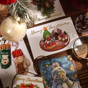 Detalle de tarjetas de felicitación navideñas con pan de oro y motivos festivos en madera