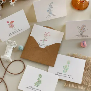 Primo piano dettagliato di eleganti biglietti d'auguri floreali vintage con buste in carta kraft