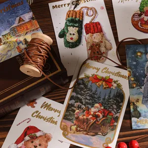 Vista detallada de tarjetas navideñas con lámina dorada y adornos de regalo rústicos.