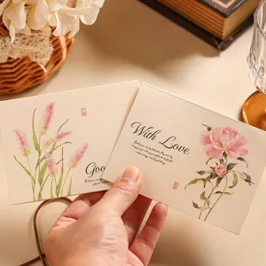 Close-up of vintage kraft greeting cards with pink floral illustrations and With Love text