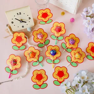 Detailed view of yellow cartoon flower lollipop decorative cards on pink surface