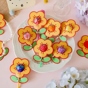 Close-up detail of colorful flower-shaped lollipop decorative paper cards on a white plate