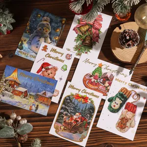 Variedad de tarjetas de felicitación navideñas con letras doradas sobre fondo de madera