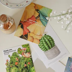 Vista detallada de tarjetas de felicitación artísticas con ilustraciones de cactus y ginkgo