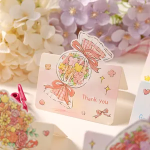 Detail shot of a pink cartoon candy-shaped thank you card featuring cute flowers.