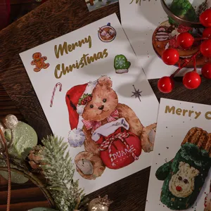 Detalle de una postal de Navidad con "Merry Christmas" en dorado y un tierno osito.
