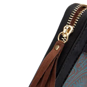 Nahaufnahme eines Retro-Lederportemonnaies mit Goldreißverschluss und Wildlederquaste
