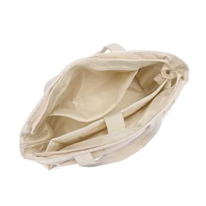 Detailed macro view showing the multiple interior compartments of a quilted cream travel bag