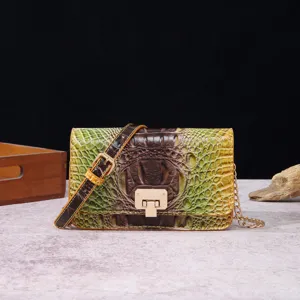 Vista detallada de un bolso bandolera vintage con grabado de cocodrilo y cierre dorado