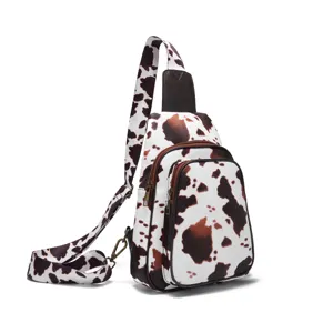 Side view of small crossbody chest bag with vintage western cow print pattern
