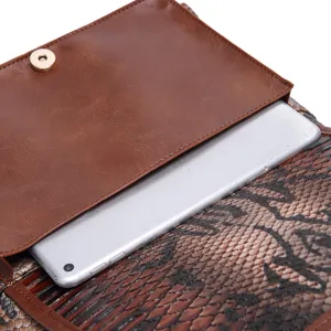 Detail of vintage snakeskin tote bag showing interior compartment with a silver tablet.