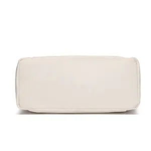 Detail view of the durable quilted base on a lightweight off-white travel duffel bag.