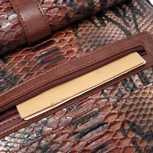Macro view showing the detailed snakeskin pattern and zipper pocket on this retro brown tote bag