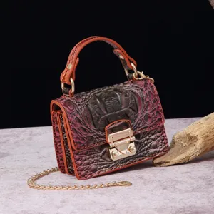 Primer plano de bolso vintage con relieve de cocodrilo y correa de cadena dorada