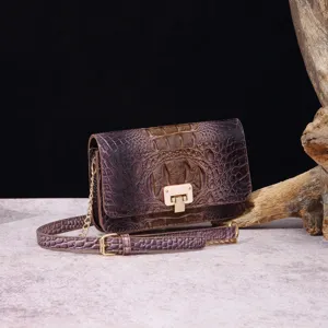 Primer plano detallado del bolso vintage violeta con relieve de cocodrilo y cierre dorado