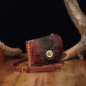 Primer plano de bolso bandolera retro con relieve de cocodrilo y herrajes dorados