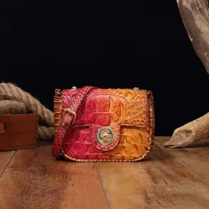 Primer plano del bolso bandolera vintage en piel de cocodrilo degradada con cierre dorado
