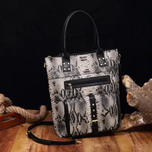 Detailed view of vintage snakeskin tote bag with black handles and metal rivets.