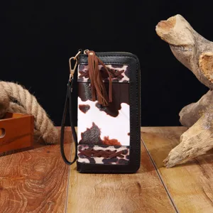 Detail einer Bohemian-Brieftasche mit Leoparden- und Kuhprints sowie braunen Quasten