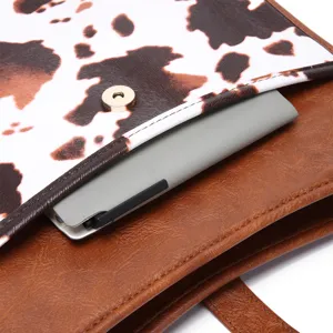 Close-up detail of cow print flap and magnetic snap on brown vintage leather crossbody bag