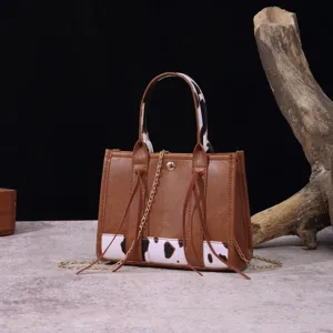 Vintage brown faux leather crossbody bag with western cow print accents and gold chain strap