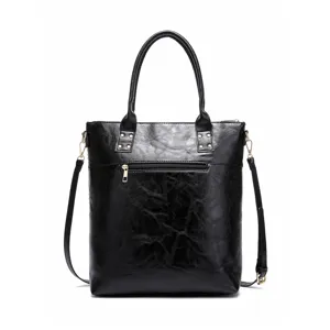 Detail view of a vintage black distressed leather tote bag with gold-tone zip pocket