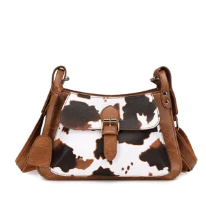 Detalle frontal de bolso bandolera con estampado de vaca vintage y ribete marrón