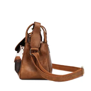 Bolso de hombro vintage de cuero sintético marrón con estampado de vaca de lado.