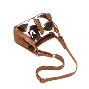 Vista detallada de un bolso bandolera vintage con estampado de vaca y correas marrones