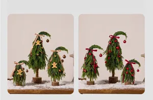 Vue détaillée de mini sapins de Noël tordus avec des décorations rouges et dorées