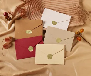 Primer plano de sobres vintage de lino con pegatinas decorativas de lacre dorado