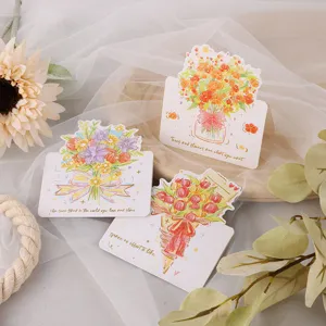 Gros plan de cartes de vœux festives avec bouquet de fleurs et dorure à l'or élégante