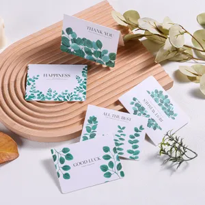 Detailweergave van wenskaarten in bosstijl met groene bladprints op houten dienblad