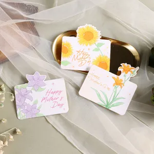 Detailed view of floral Mother's Day greeting cards with sunflower and lily designs on white gauze