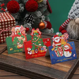 Nahaufnahme von drei festlichen Weihnachtskarten mit Weihnachtsmann und Baummotiven.
