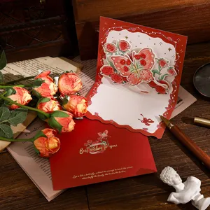 Nahaufnahme einer 3D-Pop-up-Karte mit roter Rose und Schmetterling in Goldfolie