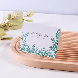 Close-up van een minimalistische wenskaart met bladontwerp en Happiness-tekst