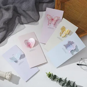Detailed view of assorted pastel 3D pop-up trifold greeting cards with hollow designs.