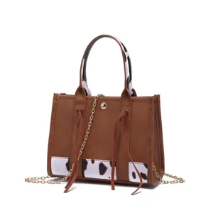 Vintage Western style mini crossbody tote bag with cow print and gold chain strap