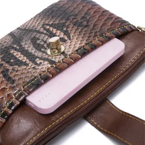 Close-up detail of snakeskin print crossbody bag showing inner pocket and phone capacity