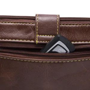 Close-up of functional zipper pocket on vintage brown leather crossbody wallet.