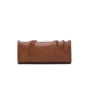 Close-up view of a vintage brown leather handbag featuring cow print and fringe details