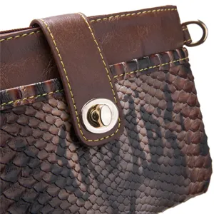 Close-up of retro bohemian handbag with brown snakeskin pattern and metallic turn-lock closure