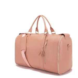 Detalle del bolso de viaje grande de cuero PU rosa con borla decorativa y bandolera