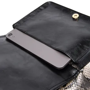Detailed macro view of the black leather bag interior showing a smartphone in a pocket