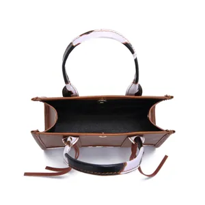 Top view showing the spacious interior and cow print handles of this mini brown tote bag.