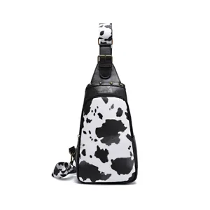 Detailed view of western style cow print sling chest bag with metallic rivets