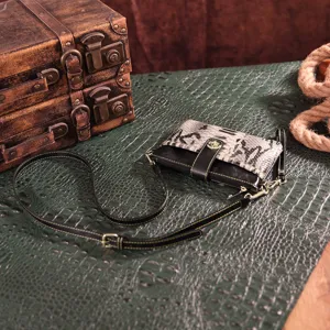 Small vintage bohemian crossbody bag with snake print detail on textured background
