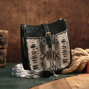 Close-up of bohemian messenger bag with vintage snake print and wide shoulder strap