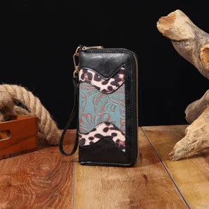 Nahaufnahme einer Boho-Leder-Clutch mit Vintage-Blumenprägung und Leopardenmuster